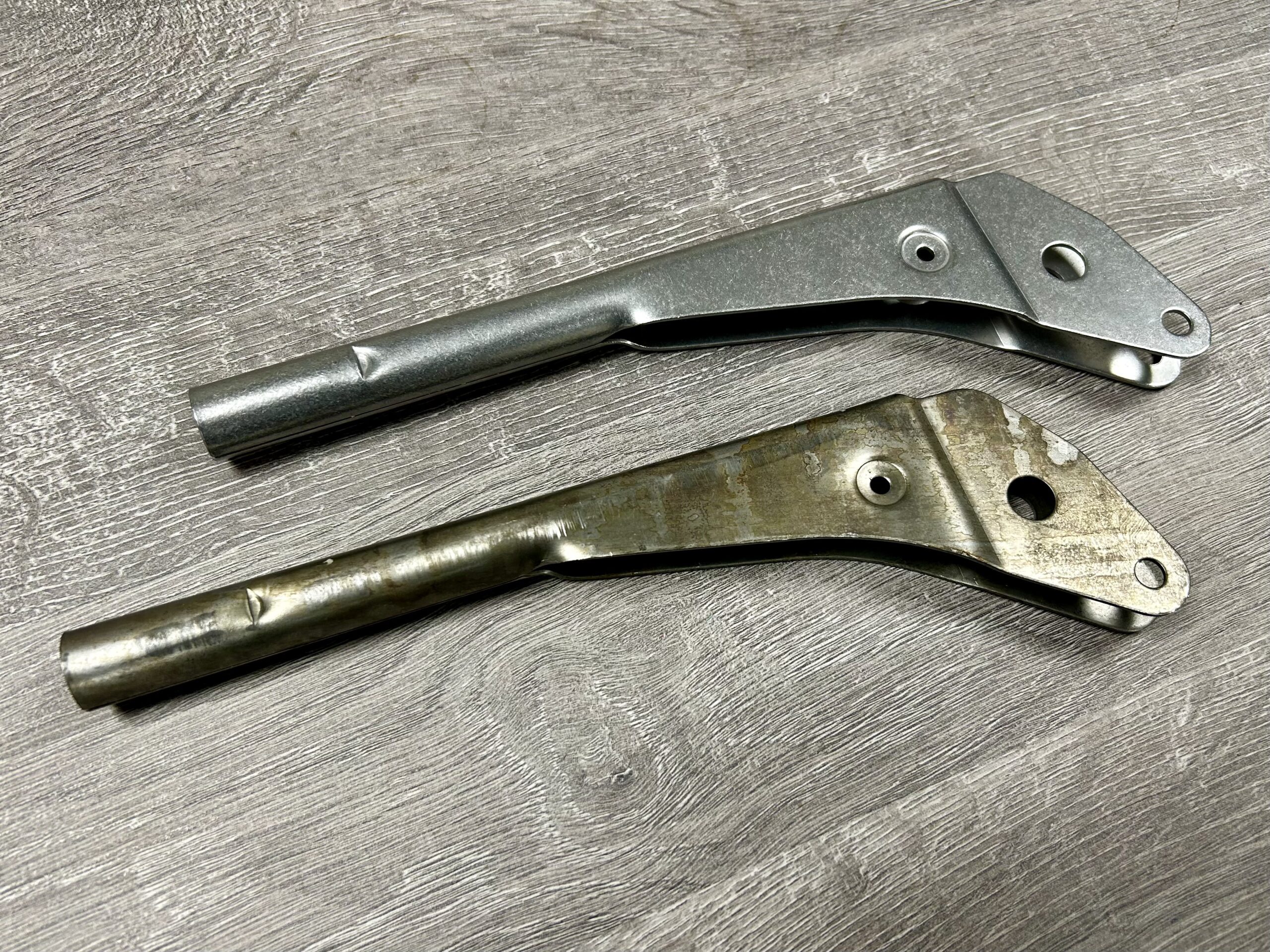 Before and after comparison of a handbrake showing rust removal and polished finish through vibratory surface finishing