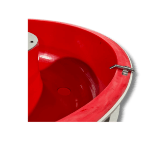 Close-up of a vibratory finishing machine bowl with red polyurethane relining, showing smooth and durable internal surface.