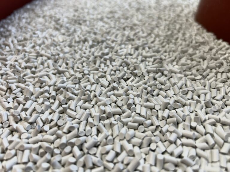Cylindrical porcelain media inside a vibratory finishing machine used for polishing components.