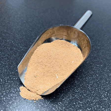 Brown SX-35S powder compound displayed on a stainless steel scoop, used for universal pre-plating and anodising of ferrous and non-ferrous metals.