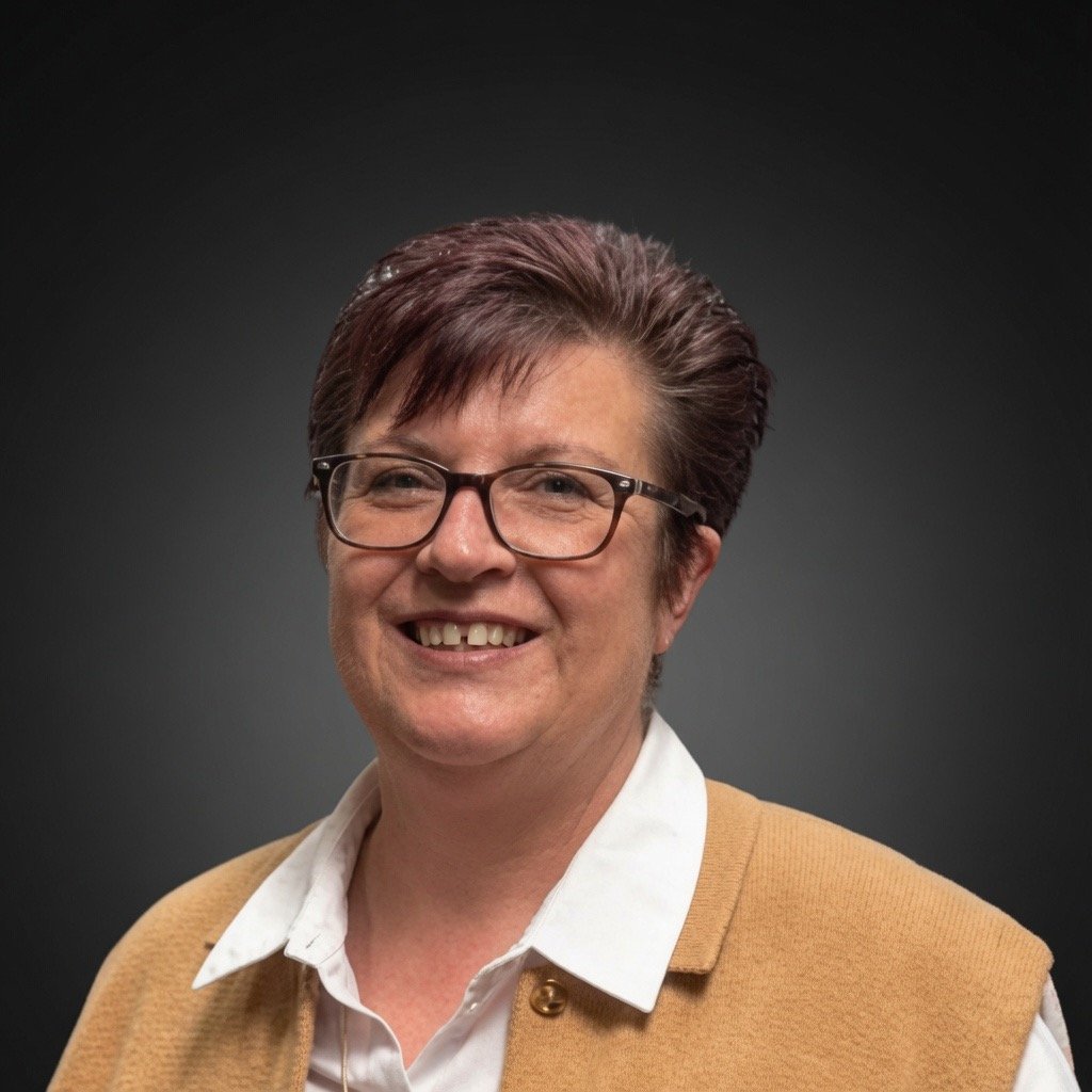 Professional portrait of Sharon Edwards, General Manager at Sharmic, overseeing operations and customer service in vibratory surface finishing.