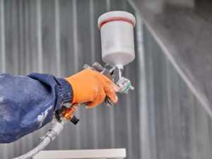 Spray gun used in spray booth for precision finishing, available as part of Sharmic’s in-house services